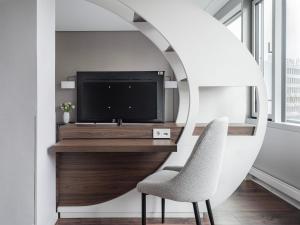 uma sala de estar com uma televisão e uma cadeira em numa I Fore Rooms & Apartments em Hamburgo