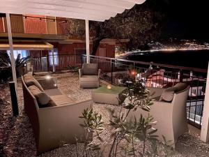 een patio met banken en een tafel op een balkon in de nacht bij Tra ulivi e mare in Laigueglia