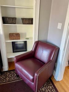 a brown leather chair in a living room with a fireplace at Travelers Delight APT with Amenities, King St 1 mi in Alexandria