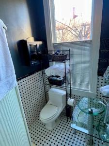 a bathroom with a toilet and a window at Travelers Delight APT with Amenities, King St 1 mi in Alexandria