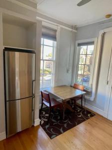 uma cozinha com uma mesa de madeira e um frigorífico em Travelers Delight APT with Amenities, King St 1 mi em Alexandria