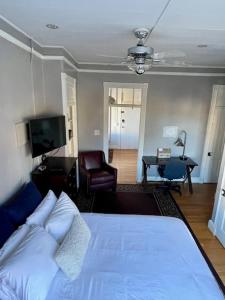 um quarto com uma cama, uma secretária e uma televisão em Travelers Delight APT with Amenities, King St 1 mi em Alexandria