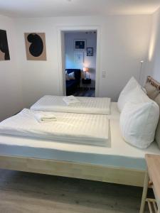 - un lit avec 2 oreillers blancs au-dessus dans l'établissement Stylische Wohnung im Herzen von Bregenz mit privatem Parkplatz, à Bregenz