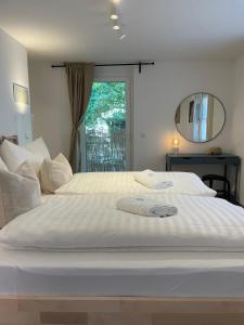ein großes weißes Bett in einem Zimmer mit Fenster in der Unterkunft Stylische Wohnung im Herzen von Bregenz mit privatem Parkplatz in Bregenz
