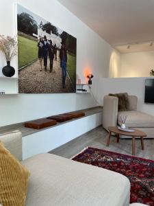 ein Wohnzimmer mit einem Sofa und einem Gemälde an der Wand in der Unterkunft Stylische Wohnung im Herzen von Bregenz mit privatem Parkplatz in Bregenz