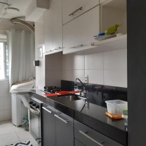 a kitchen with white cabinets and a sink at Canto do sabiá in Rio de Janeiro