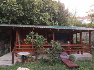 um pavilhão de madeira com um banco e uma mesa em Kamp Seosko domaćinstvo Radman em Herceg Novi