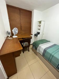 1 dormitorio con escritorio y 1 cama con ventilador en Apartamento em Ipanema Melhor localização en Río de Janeiro