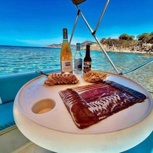 - une table avec de la nourriture et des bouteilles de vin sur un bateau dans l'établissement Villa Saint-Michel, à Galéria