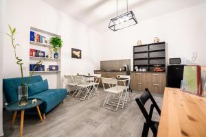 ein Wohnzimmer mit einem blauen Sofa und einer Küche in der Unterkunft Il Cortile Degli Artisti in Marsala