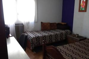 um quarto com um sofá, uma cama e uma janela em Habitación privada en Casa Musical I em Mar del Plata