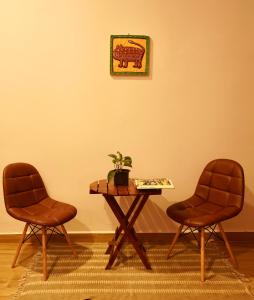 Dos sillas y una mesa con una maceta. en The Flying Squirrel Bandhavgarh en Umariā