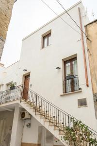 a white building with a staircase and windows at B&B Il Cortile Degli Artisti in Marsala