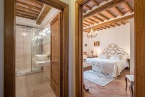 a bedroom with a bed and a bathroom at Mulino Di Quercegrossa in Quercegrossa