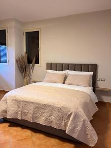 a large bed in a bedroom with a window at Belix Hotel Apartments, Near the Beach in Durrës