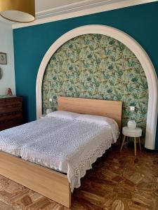 1 dormitorio con 1 cama grande y pared azul en Casa Cele centro città vista mare, en Ventimiglia