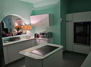 a kitchen with green walls and white cabinets at Angel Bay, 129 Nkwazi Drive, Zinkwazi in Zinkwazi Beach