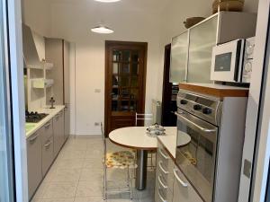 a kitchen with a table and a microwave at Casa Cele centro città vista mare in Ventimiglia