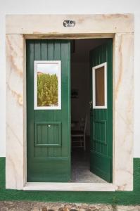 a green door in a building with a window at Refugio do Rossio in Avis