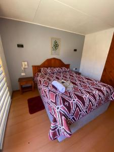 a bedroom with a bed with a colorful comforter at Tierras Del Sol in Quilpué