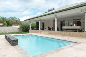 - une piscine en face d'une maison dans l'établissement Villa-Aquaterra-Hideaway-piscine-Barbecue, à Matoury