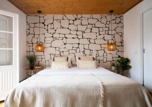 um quarto com uma grande cama branca e 2 almofadas em Sé Velha Suites em Coimbra