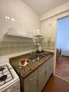 cocina con fregadero y fogones en Apartamento Carlota en Buenos Aires