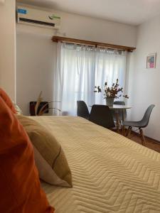Un dormitorio con una cama grande y una mesa con sillas. en Apartamento Carlota en Buenos Aires