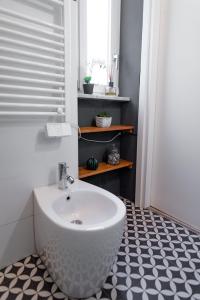 baño con lavabo blanco y suelo blanco y negro en Appartamento Lingotto, en Turín