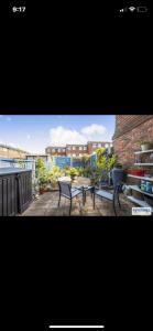 a view of a patio with a table and chairs at A Perfect Two Bedroom House for a Family Stay in Havering atte Bower