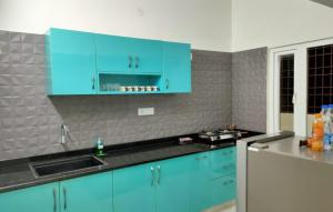 瓦拉納西的住宿－The Kutumb- Holiday Home，厨房配有蓝色橱柜和水槽