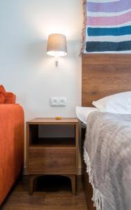 łóżko i stolik nocny z lampką obok łóżka w obiekcie New Gudauri Twins Apartment w mieście Gudauri
