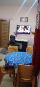 uma sala de jantar com uma mesa e cadeiras e uma televisão em The Kutumb- Holiday Home em Varanasi