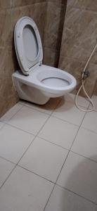 瓦拉納西的住宿－The Kutumb- Holiday Home，浴室铺有白色瓷砖地板,设有白色卫生间。
