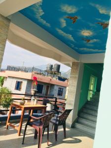 un patio con mesa y sillas y un techo azul en Pokhara favourite apartment, en Pokhara