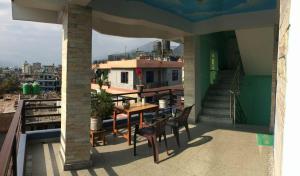 - Balcón con mesa y sillas en un edificio en Pokhara favourite apartment, en Pokhara