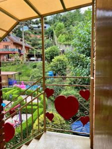 a screened in porch with hearts on the window at Vila husky pousada in Campos do Jordão