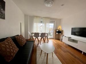 ein Wohnzimmer mit einem Sofa und einem Tisch in der Unterkunft Holiday Apartment NAMASTAY in Küssaberg