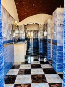 a bathroom with blue and white tiles and a checkered floor at Magic land taba camp in Taba