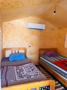 a bedroom with two beds in a wooden cabin at Magic land taba camp in Taba