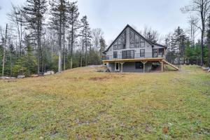 a large house on top of a grassy hill at Mountain-View Bethel Cabin Game Room and Deck in Bethel