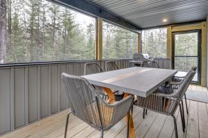 un porche cubierto con mesa y sillas en Mountain-View Bethel Cabin Game Room and Deck, en Bethel