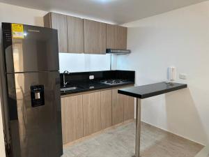 a kitchen with a black refrigerator and a counter at Apartamento Victoria in Puerto Colombia