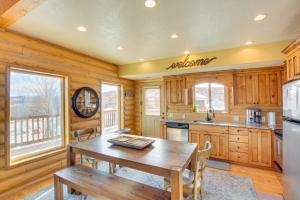 a kitchen with wooden cabinets and a wooden table at Garden City Cabin about 6 Mi to Bear Lake State Park! in Garden City