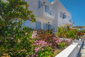 a white building with flowers in front of it at Aeolis Hotel in Adamas