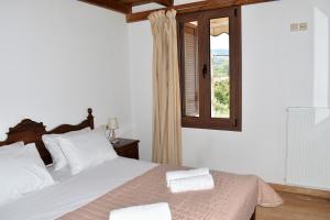 1 dormitorio con 1 cama con sábanas blancas y ventana en Madaro Traditional House en Arménoi