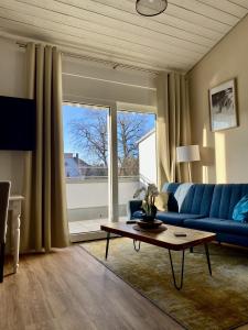 巴特塞京根的住宿－Gemütliches Galerie Apartment，客厅配有蓝色的沙发和桌子