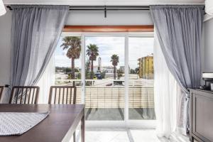 a dining room with a large window with a view at FURADOURO - Vista dos Pinhais - apart 2 quartos a 100 metros da praia do Furadouro in Ovar