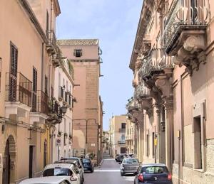 a street with cars parked on the sides of buildings at Casa Frisella in Marsala