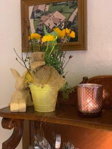 eine gelbe Vase mit gelben Blumen auf einem Tisch in der Unterkunft Pension Gregory in Schönau am Königssee